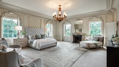 a large bedroom with a fireplace and chandelier