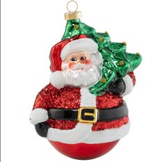 a glass ornament with a santa clause holding a christmas tree