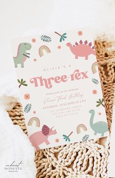 there is a pink and green dinosaur birthday party card on the wicker basket with it's name