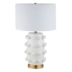 a white table lamp with a gold base