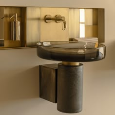 a bathroom sink sitting under a mirror next to a wall mounted faucet