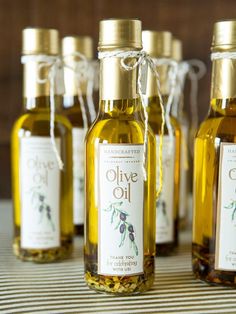 five bottles of olive oil sitting on top of a table