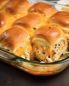 a casserole dish filled with chicken sliders and melted cheese on the top