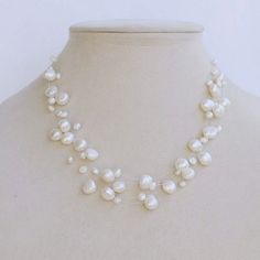 a white necklace on a mannequin with pearls