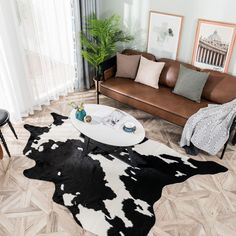 a living room filled with furniture and a cow skin rug