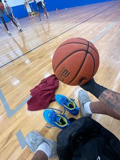 a man laying on the floor with his feet up next to a basketball