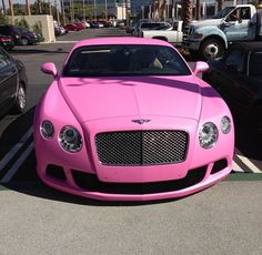 a pink car is parked in a parking lot