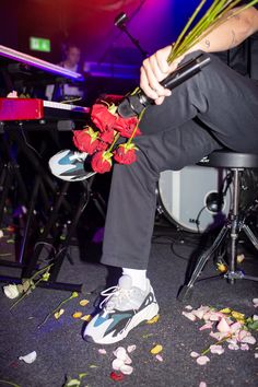 a person sitting on a chair with flowers in their lap