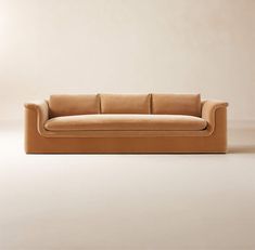 a tan couch sitting on top of a white floor next to a wall in an empty room