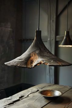 a wooden table with a bowl on it and a light fixture hanging from the ceiling