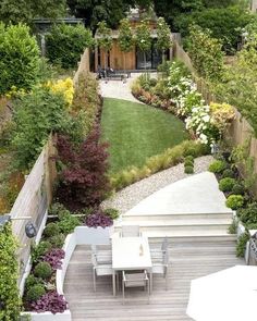 an outdoor patio with tables and chairs surrounded by trees, bushes, and flowers in the background