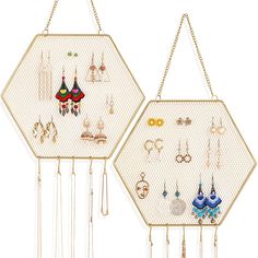 two gold hexagonal wall hangings with earrings on them