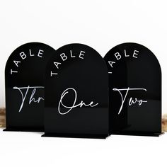 three black acrylic signs with white writing on them