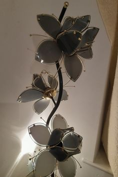 a pair of sunglasses is hanging from a metal flower with glasses attached to the stems