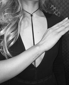 a woman wearing a necklace and holding her hands together