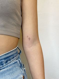 a woman's left arm with a tiny star tattoo on the right side of her upper arm