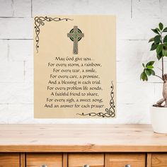 a wooden table topped with a potted plant next to a cross