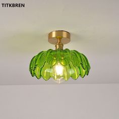 a green glass light fixture hanging from the ceiling