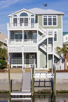 a house on the water with stairs leading up to it's second floor and second story