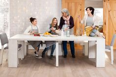 a group of people sitting around a white table