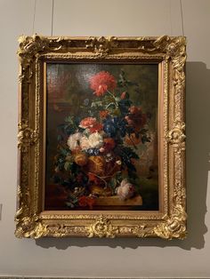 a painting hanging on the wall with flowers in it