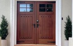 two wooden doors on the side of a house