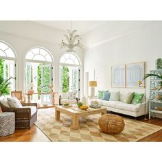 a living room filled with furniture and lots of windows next to a wooden coffee table