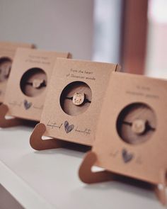 three cardboard boxes with buttons in them sitting on a table