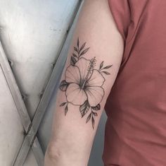 a woman's arm with a flower tattoo on the left side of her arm