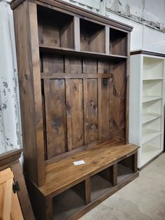 a wooden bench sitting in the middle of a room next to some bookshelves