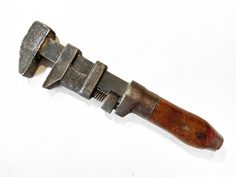 an old metal and wood tool on a white surface