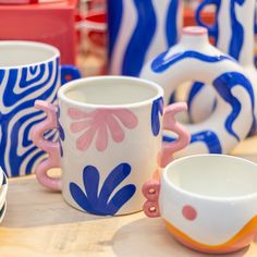 several colorful cups and bowls on a table