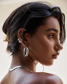 a close up of a person wearing some kind of earring and looking off to the side