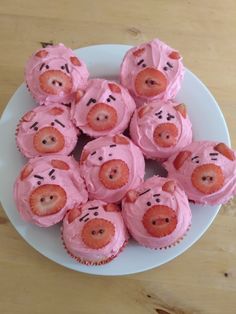 cupcakes with pink frosting and teddy bears on them are arranged in the shape of pigs