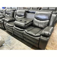 two reclining leather sofas with power headrests and foot rests on the floor