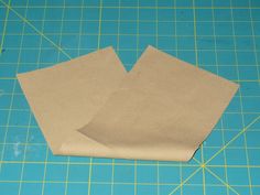 two pieces of brown paper sitting on top of a cutting board