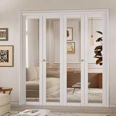 a living room filled with furniture and lots of white glass doors that open to the outside