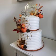 a three tiered cake decorated with fall leaves and acorns