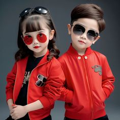 two children in red jackets and sunglasses standing next to each other with their hands on their hips