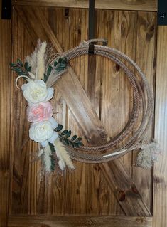 a rope with flowers and feathers attached to it on a wooden wall next to a door