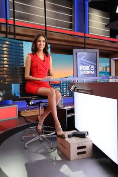 a woman in a red dress sitting at a desk