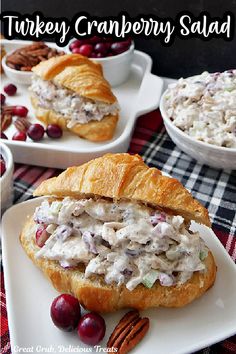 turkey cranberry salad in a croissant roll on a plate with pecans