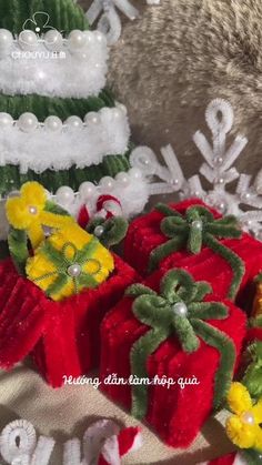 three red and green christmas gifts sitting next to each other on a white table cloth