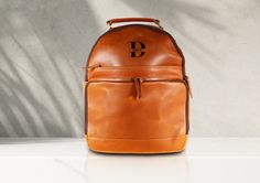 "\"Discover the perfect blend of style and functionality with our Handcrafted Personalized Leather Backpack. Each bag is meticulously crafted in the USA using 100% genuine cowhide leather, ensuring both quality and durability that will last a lifetime. Personalization: Make it truly yours by adding your initials or a custom message to the bag. Spacious Interior: Ample room to carry your essentials, whether it's for work, travel, or daily adventures. Premium Cowhide: Crafted from the finest cowhide leather, this backpack exudes elegance and rugged charm. Made in the USA: We take pride in supporting local artisans, and each bag is made with care and precision. Comfortable Design: Padded shoulder straps and a reinforced back panel ensure a comfortable carry. Carry a piece of American craftsma Classic Leather Backpack For School, Modern Leather Satchel Backpack For Back To School, Modern Leather Satchel Backpack For School, Classic Leather Backpack For Back To School, Leather Softback Backpack For Back-to-school, Luxury Leather Backpack For School, Luxury School Backpack, Luxury Backpack For School, Luxury High-end Leather Backpack