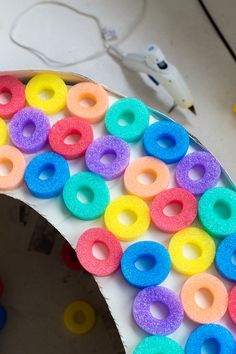 there is a cake decorated with multicolored doughnuts