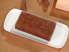 a piece of cake sitting on top of a white plate next to a knife and fork