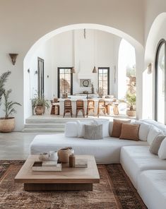 a living room filled with white furniture and lots of natural light coming in from the windows