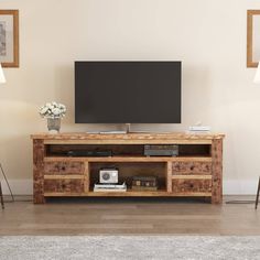 an entertainment center with a flat screen tv mounted on it's side, in a living room