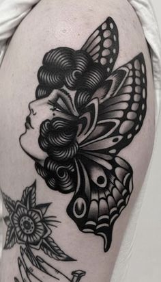 a woman's thigh with a butterfly and flowers on the back of her leg