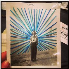 a person holding up a photo with blue sticks on it